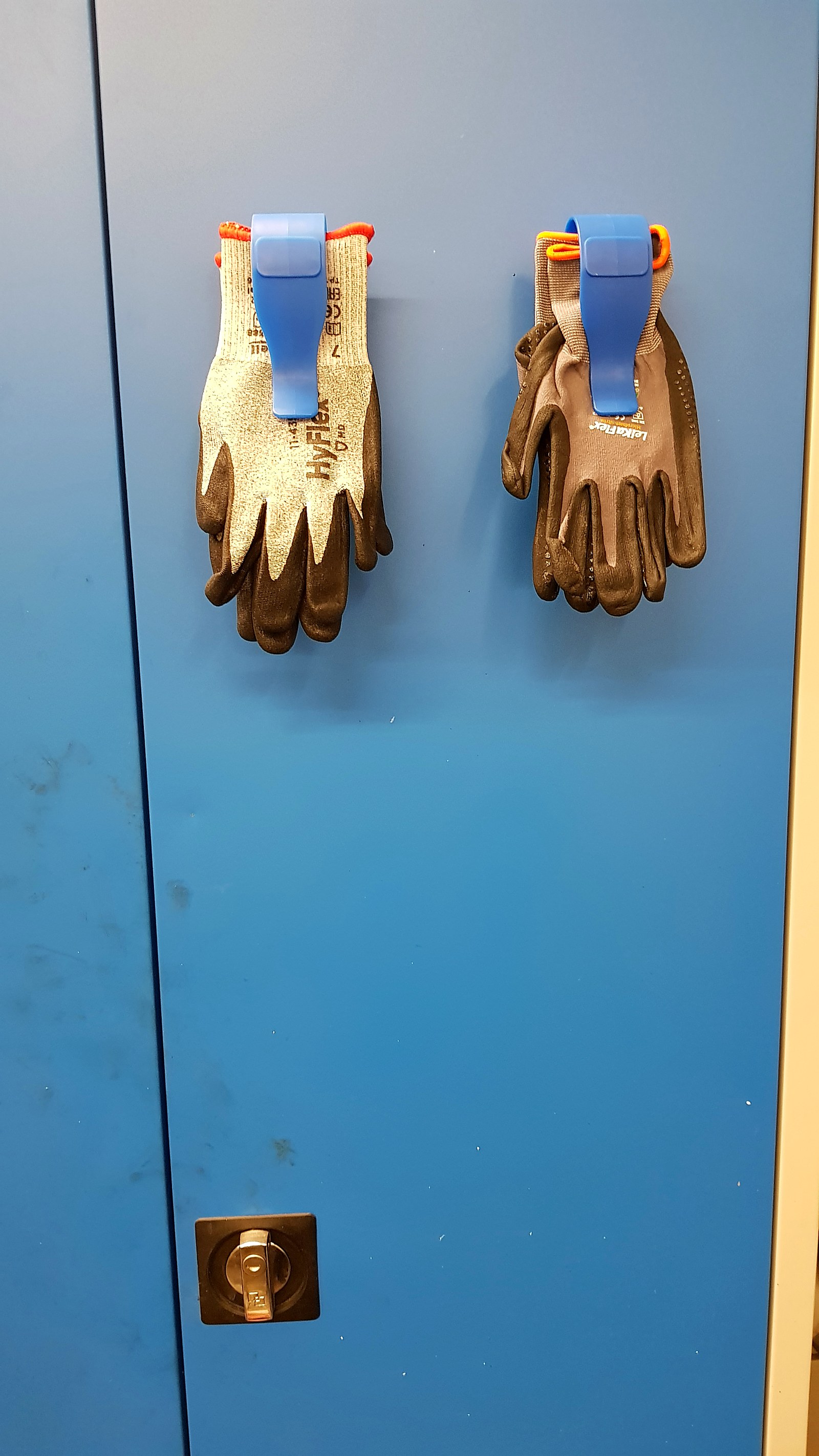 Handschuh-Halter an einer Fliesenwand mit zwei Handschuhpaaren