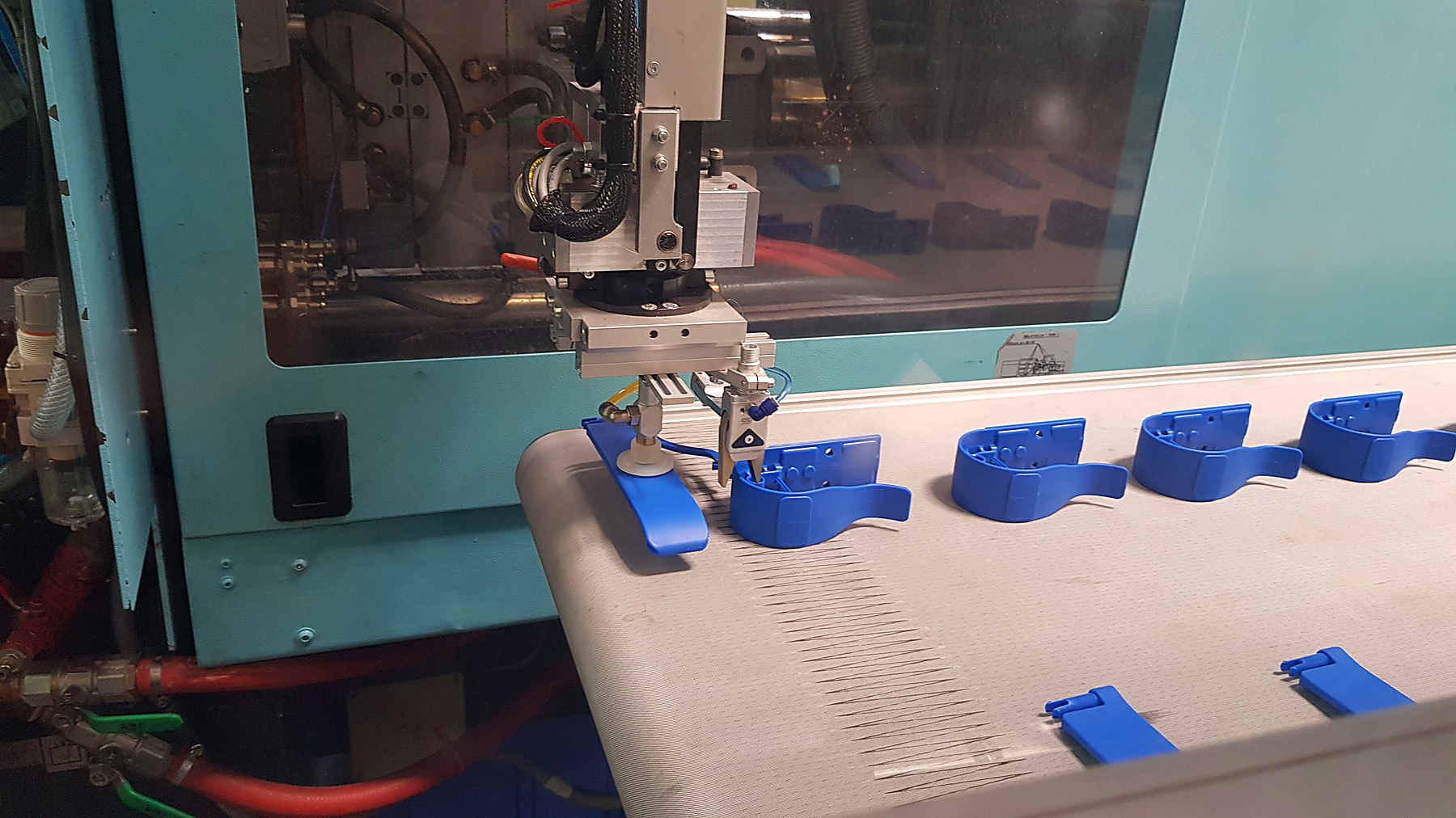 Roboterarm entnimmt ein frisch gespritztes Teil